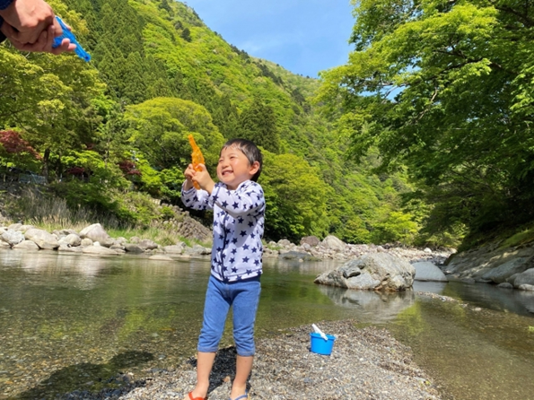 アウトドアで人気の川遊びをしている画像